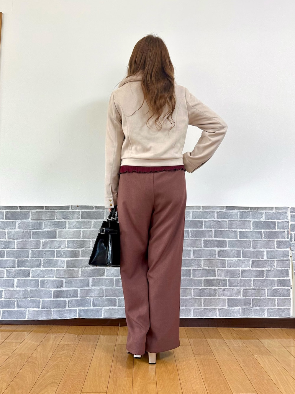 パープル系のダッフルコート、レッド系のTシャツ/カットソー、ベージュ系のパンプスを着用したレディースの冬コーディネートの5枚目の写真