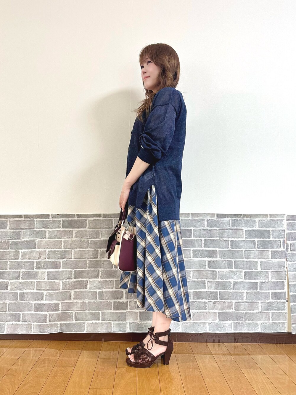 レッド系のタンクトップ、ブルー系のカーディガン/ボレロ、ブルー系のスカートを着用したレディースの夏コーディネートの3枚目の写真