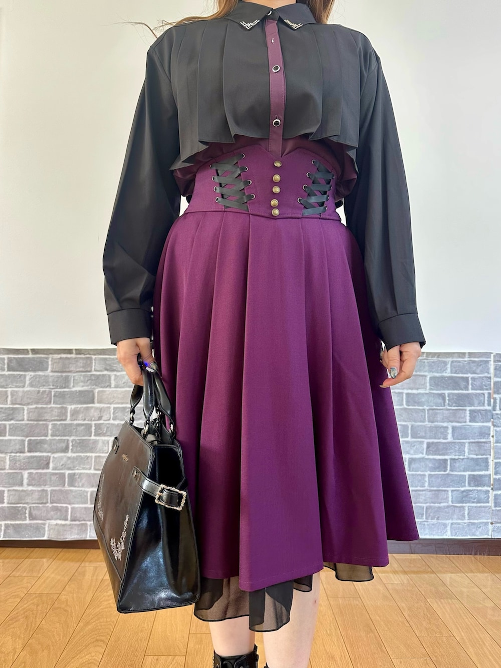 ブラック系のシャツ/ブラウス、ブラック系のカーディガン/ボレロ、パープル系のスカートを着用したレディースの秋コーディネートの5枚目の写真