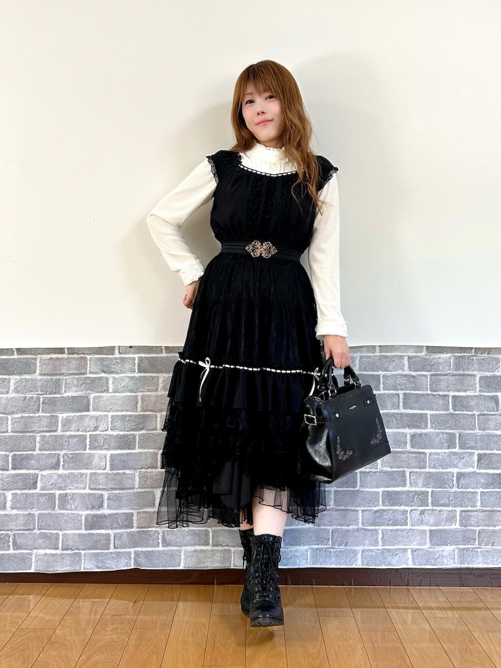 ピンク系のピーコート、ブラック系のスカート、ブラック系のボストンバッグを着用したレディースの秋コーディネートの3枚目の写真