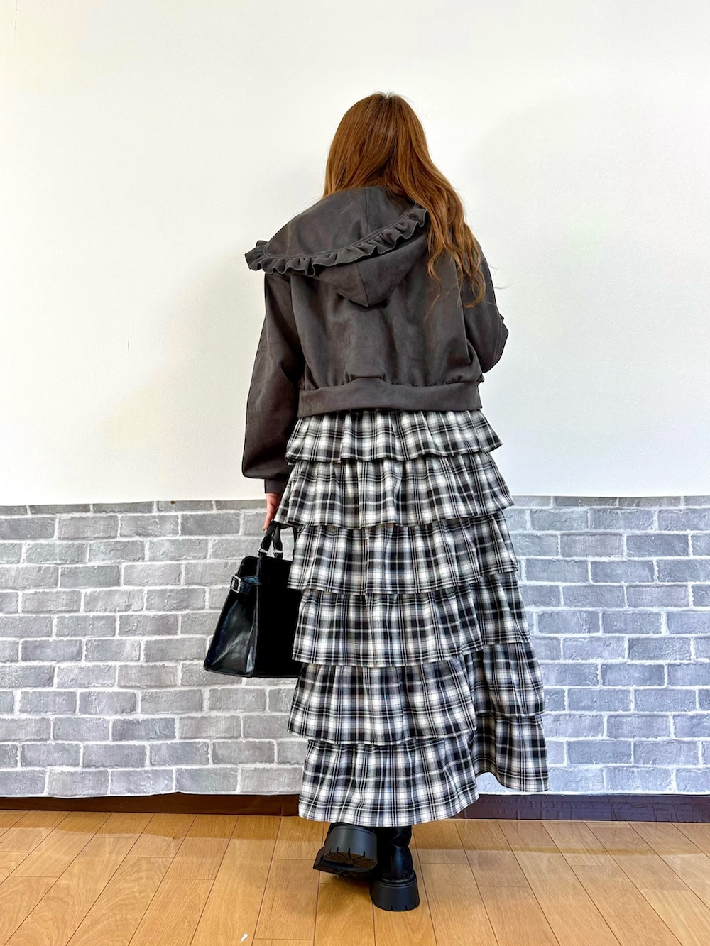 グレー系のパーカー、レッド系のニット/セーター、レッド系のスカートを着用したレディースの秋コーディネートの4枚目の写真