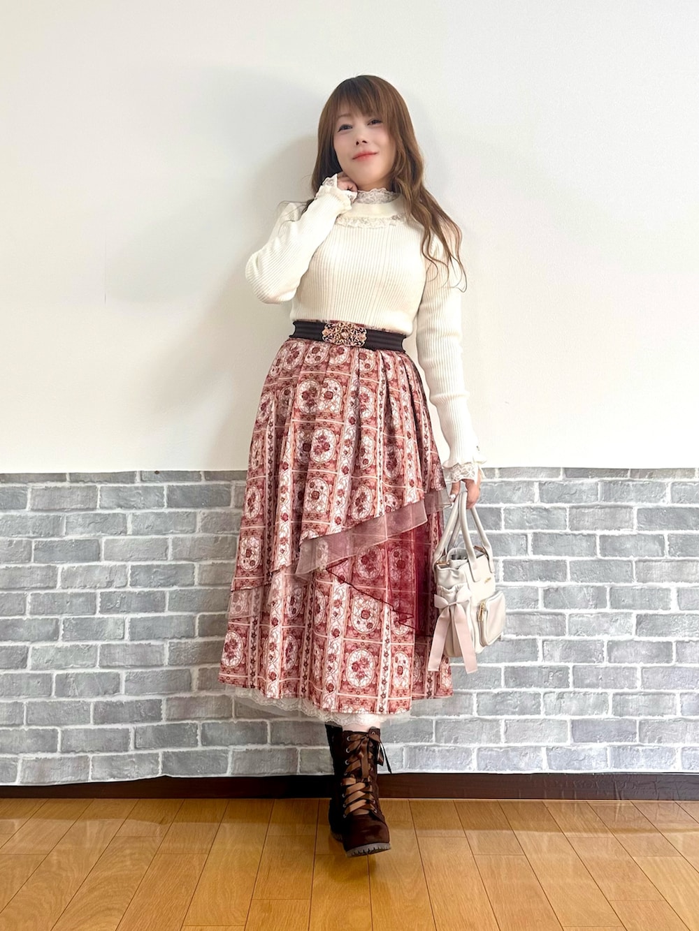 レッド系のダッフルコート、ホワイト系のTシャツ/カットソー、ホワイト系のニット/セーターを着用したレディースの冬コーディネートの2枚目の写真