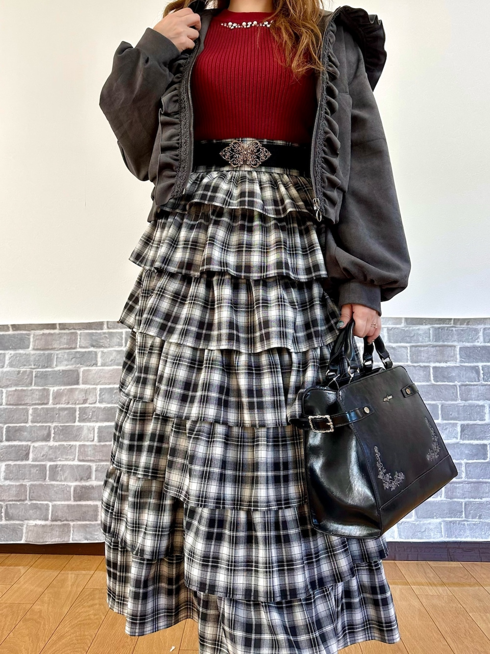 グレー系のパーカー、レッド系のニット/セーター、レッド系のスカートを着用したレディースの秋コーディネートの5枚目の写真