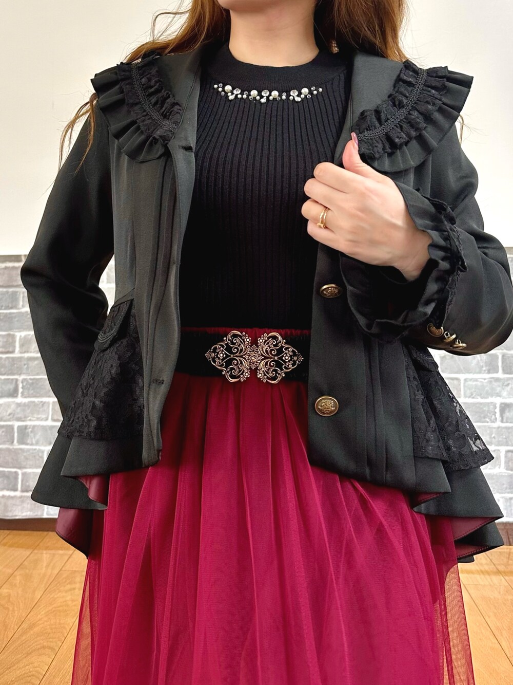 ブラック系のテーラードジャケット、ブラック系のニット/セーター、ホワイト系のタンクトップを着用したレディースの秋コーディネートの6枚目の写真