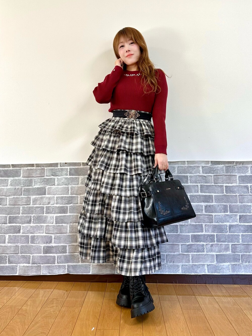 グレー系のパーカー、レッド系のニット/セーター、レッド系のスカートを着用したレディースの秋コーディネートの2枚目の写真