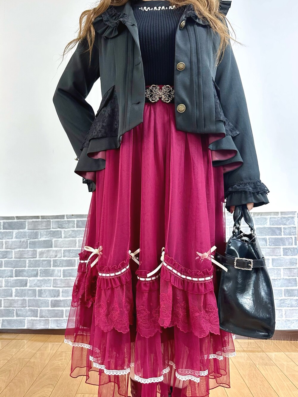 ブラック系のテーラードジャケット、ブラック系のニット/セーター、ホワイト系のタンクトップを着用したレディースの秋コーディネートの5枚目の写真