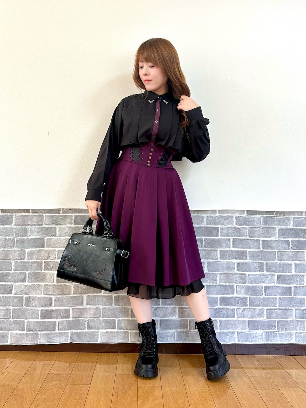 ブラック系のシャツ/ブラウス、ブラック系のカーディガン/ボレロ、パープル系のスカートを着用したレディースの秋コーディネートの2枚目の写真