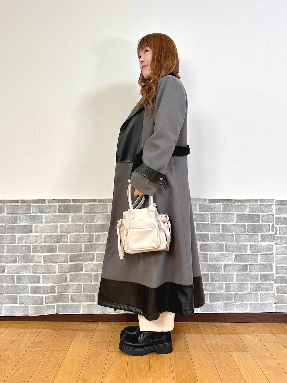 グレー系のダッフルコート、ブルー系のニット/セーター、ベージュ系のその他パンツを着用したレディースの秋コーディネートの4枚目の写真