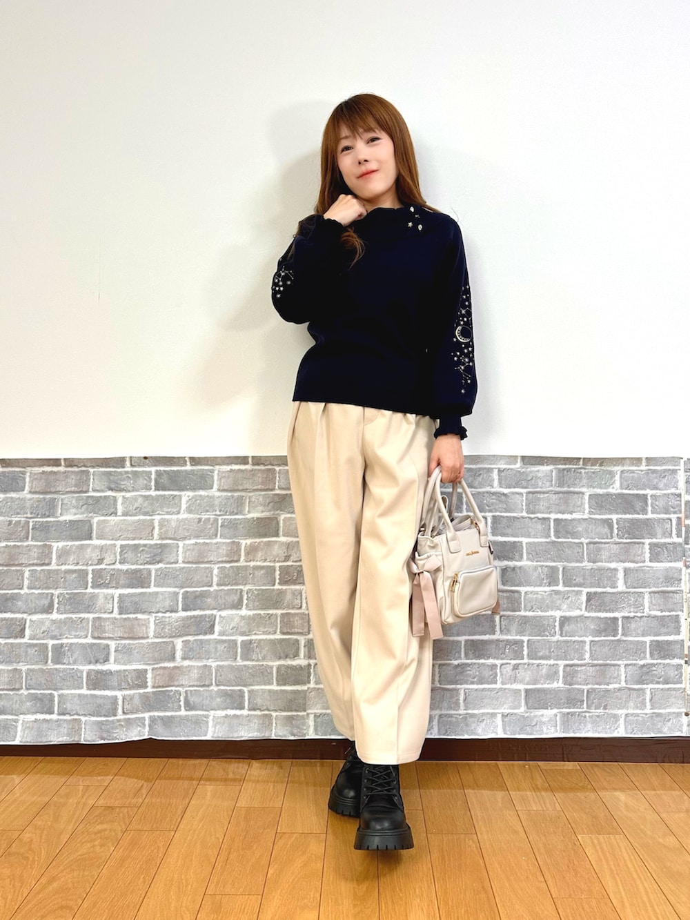 グレー系のダッフルコート、ブルー系のニット/セーター、ベージュ系のその他パンツを着用したレディースの秋コーディネートの3枚目の写真