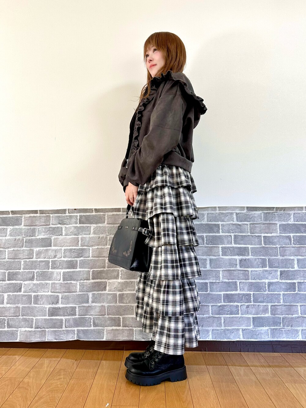 グレー系のパーカー、レッド系のニット/セーター、レッド系のスカートを着用したレディースの秋コーディネートの3枚目の写真