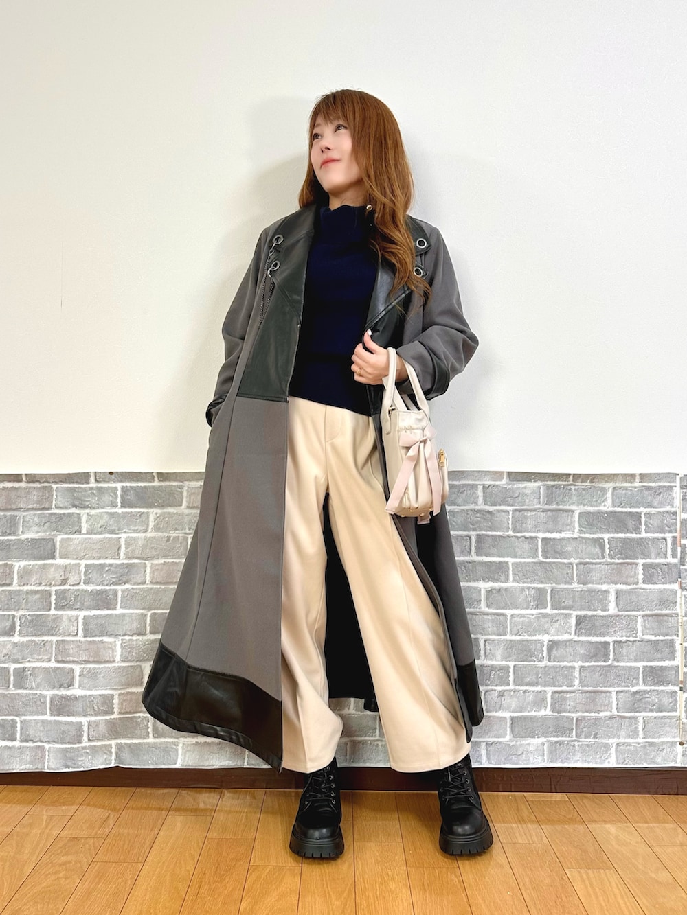 グレー系のダッフルコート、ブルー系のニット/セーター、ベージュ系のその他パンツを着用したレディースの秋コーディネートの6枚目の写真