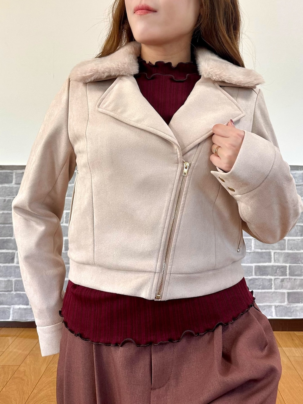 パープル系のダッフルコート、レッド系のTシャツ/カットソー、ベージュ系のパンプスを着用したレディースの冬コーディネートの6枚目の写真