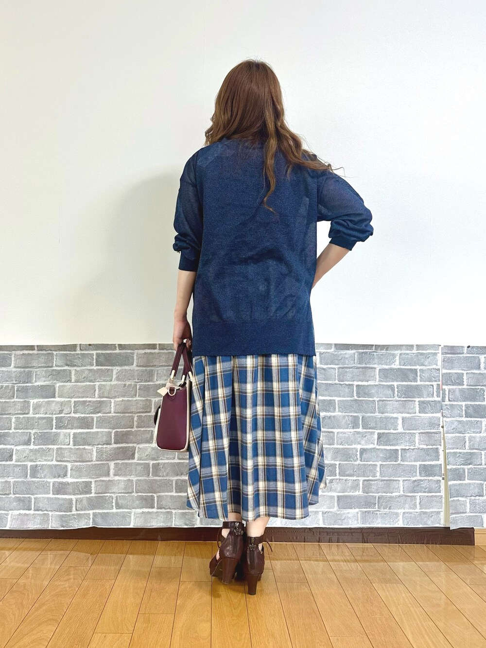 レッド系のタンクトップ、ブルー系のカーディガン/ボレロ、ブルー系のスカートを着用したレディースの夏コーディネートの4枚目の写真