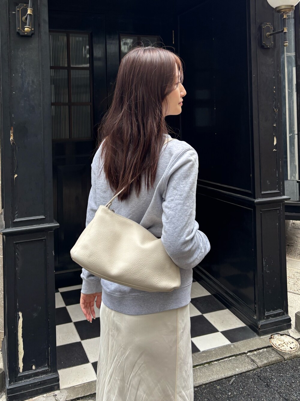 ホワイト系のショルダーバッグを着用したレディースの秋コーディネートの2枚目の写真