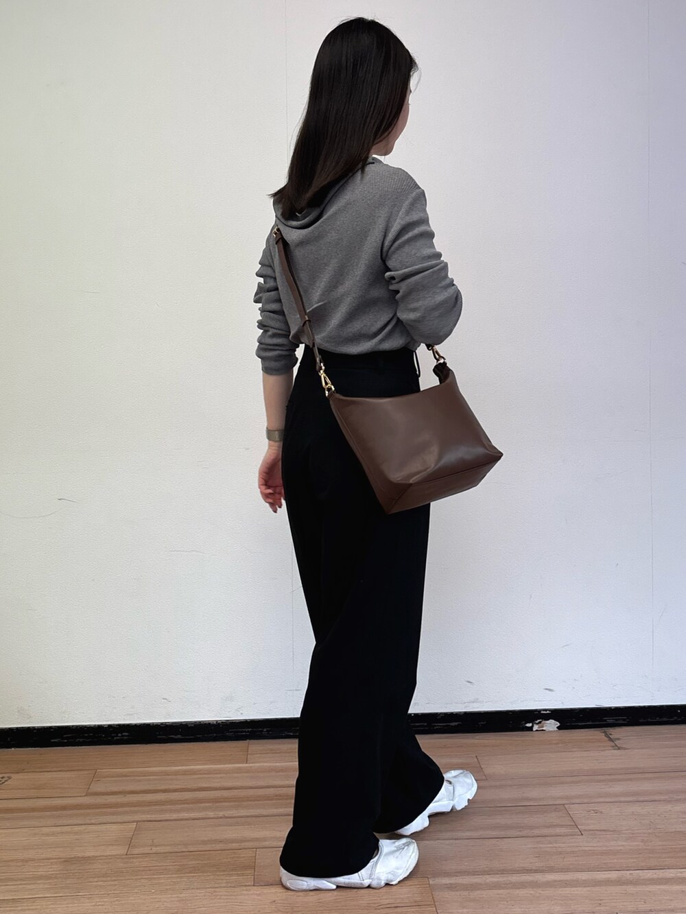 ブラウン系のショルダーバッグ、グレー系のニット/セーターを着用したレディースの春コーディネートの4枚目の写真