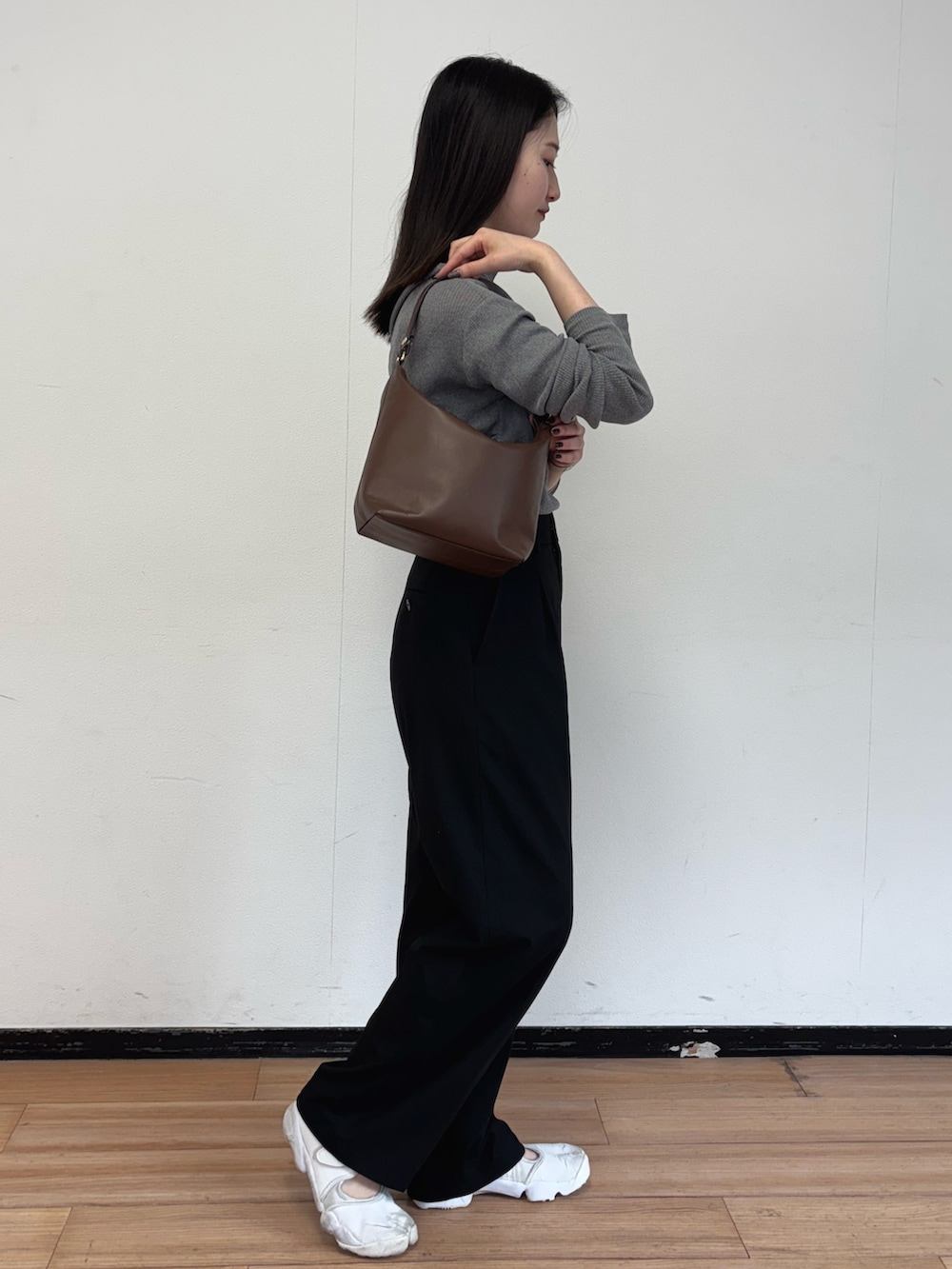 ブラウン系のショルダーバッグ、グレー系のニット/セーターを着用したレディースの春コーディネートの3枚目の写真