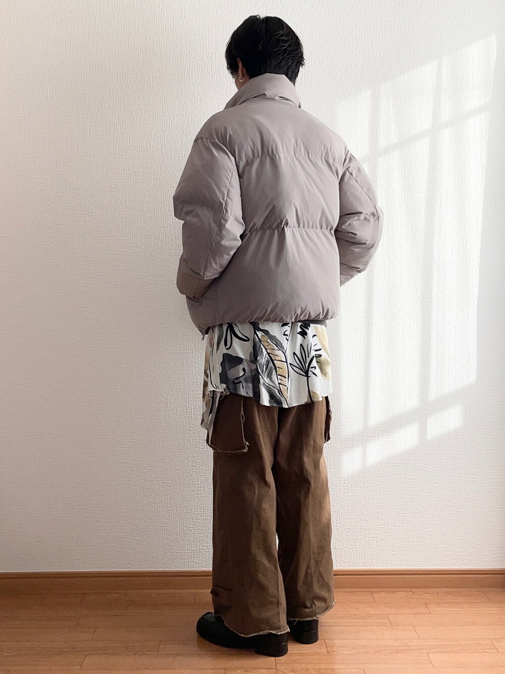 ベージュ系のダウンジャケット/コート、ブラック系のニット/セーター、ブラウン系のカーゴパンツを着用したメンズの冬コーディネートの3枚目の写真