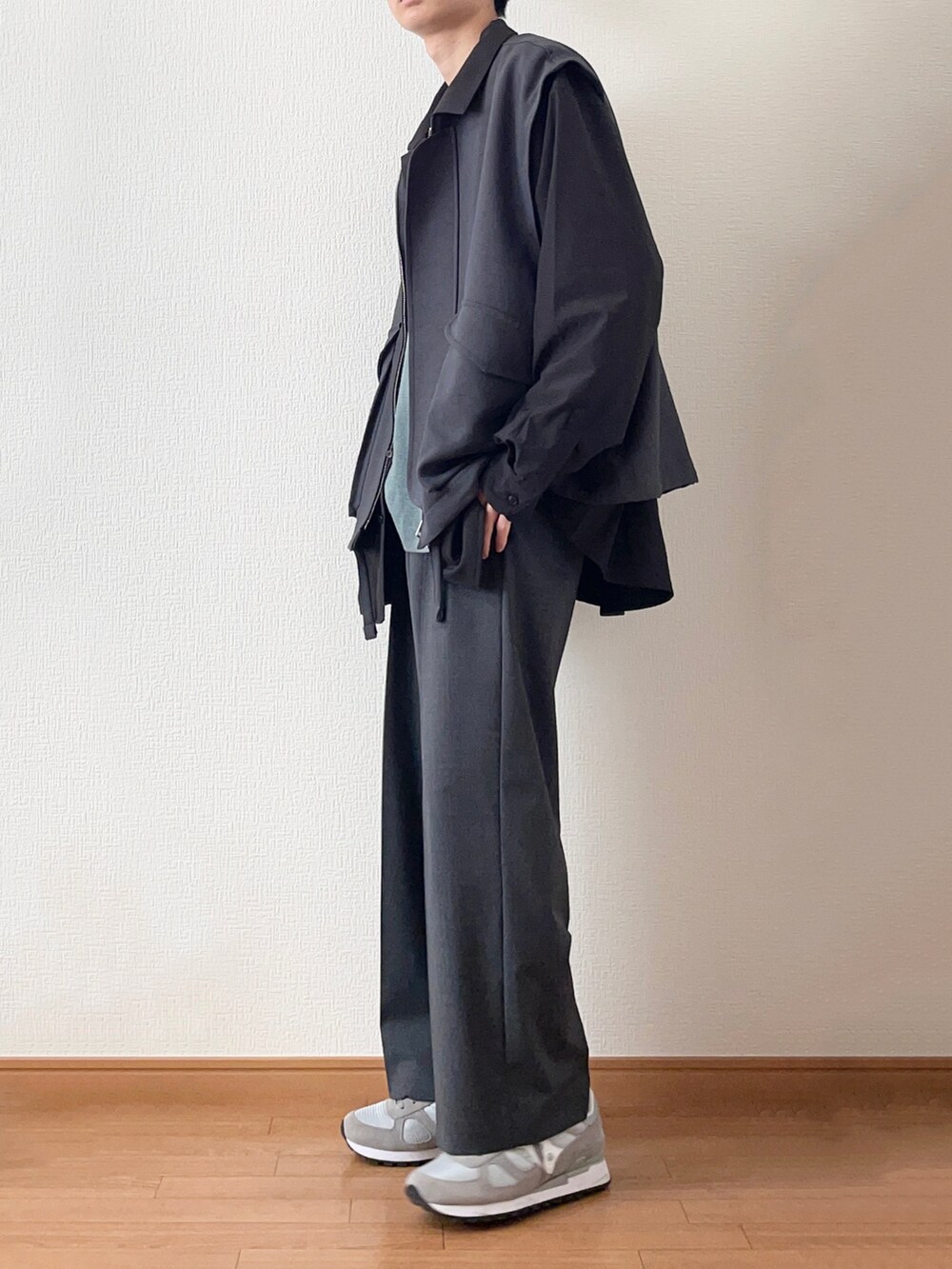 グレー系のブルゾン、ブラック系のシャツ/ブラウス、グリーン系のニット/セーターを着用したメンズの冬コーディネートの2枚目の写真