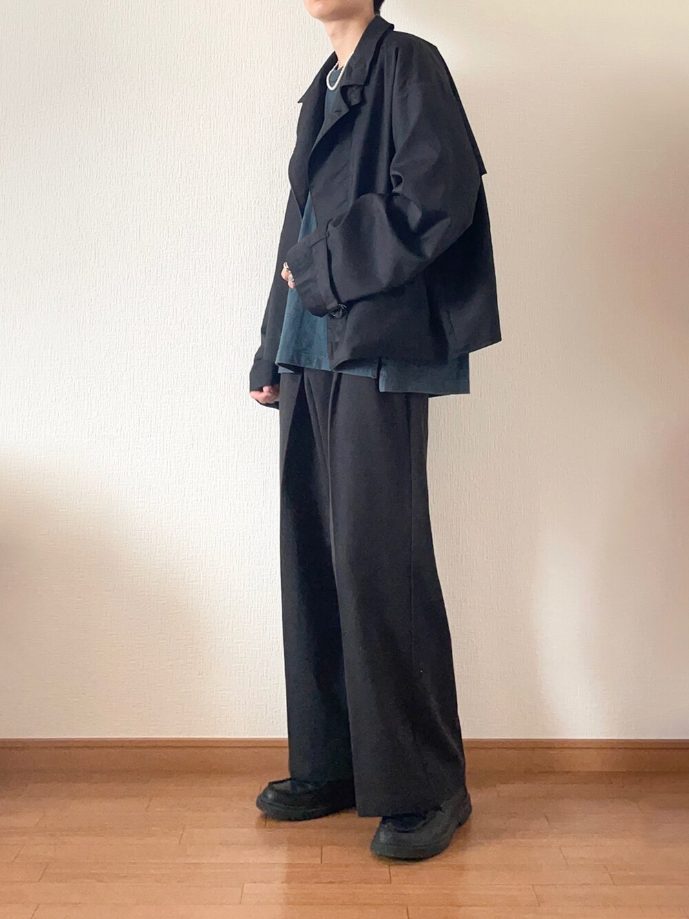 ブラック系のテーラードジャケット、ブラック系のその他パンツ、ブルー系のTシャツ/カットソーを着用したメンズの秋コーディネートの2枚目の写真