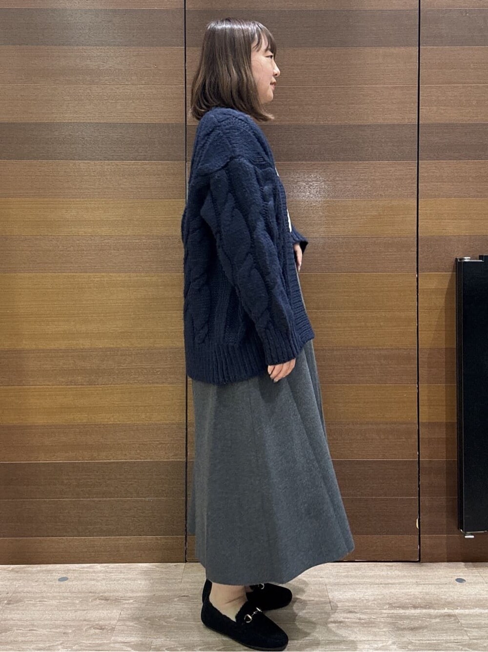 ブルー系のカーディガン/ボレロ、ホワイト系のニット/セーター、グレー系のスカートを着用したレディースの冬コーディネートの7枚目の写真