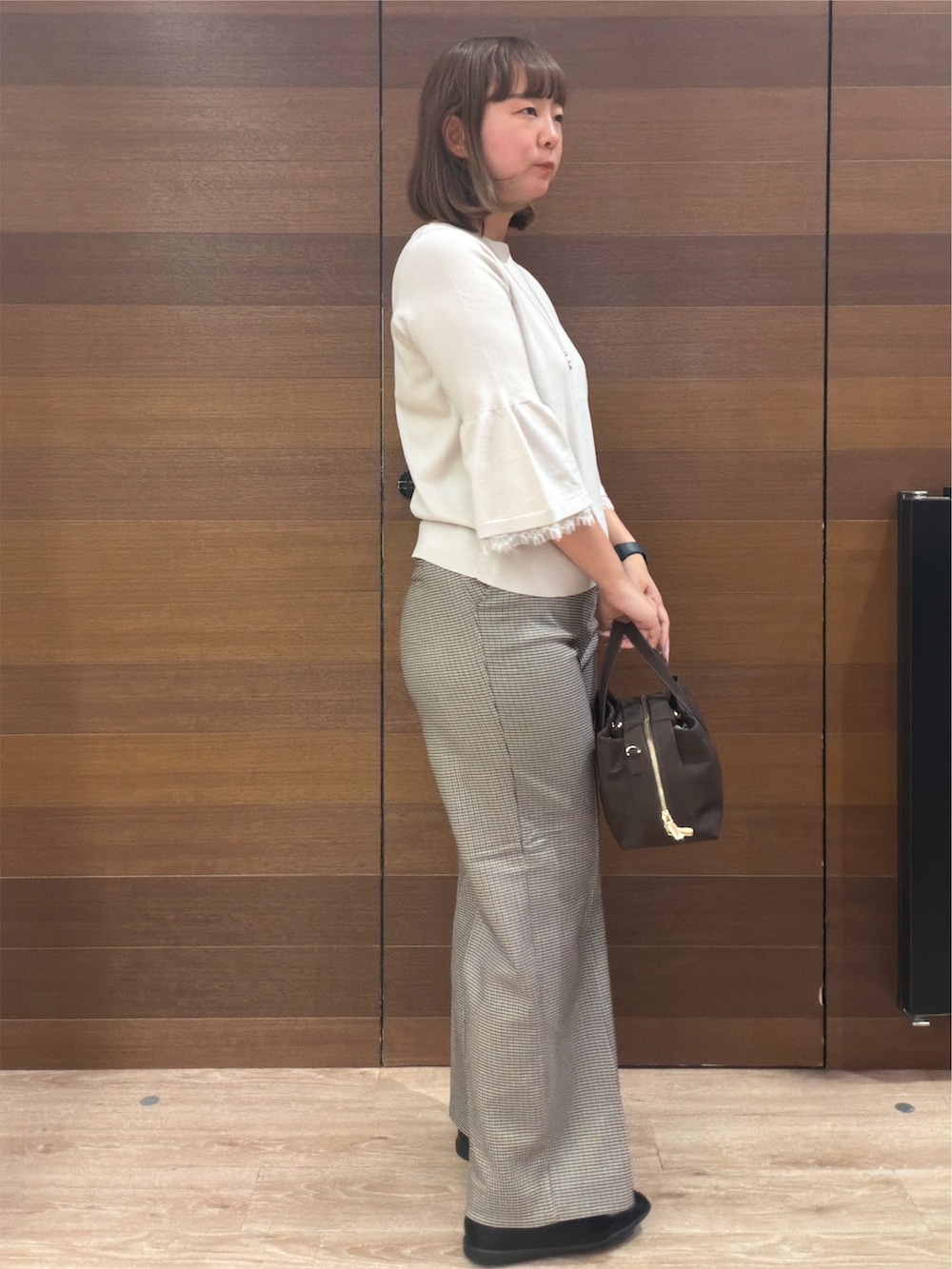 ベージュ系のニット/セーター、ブラウン系のその他パンツ、ブラウン系のボストンバッグを着用したレディースの秋コーディネートの7枚目の写真