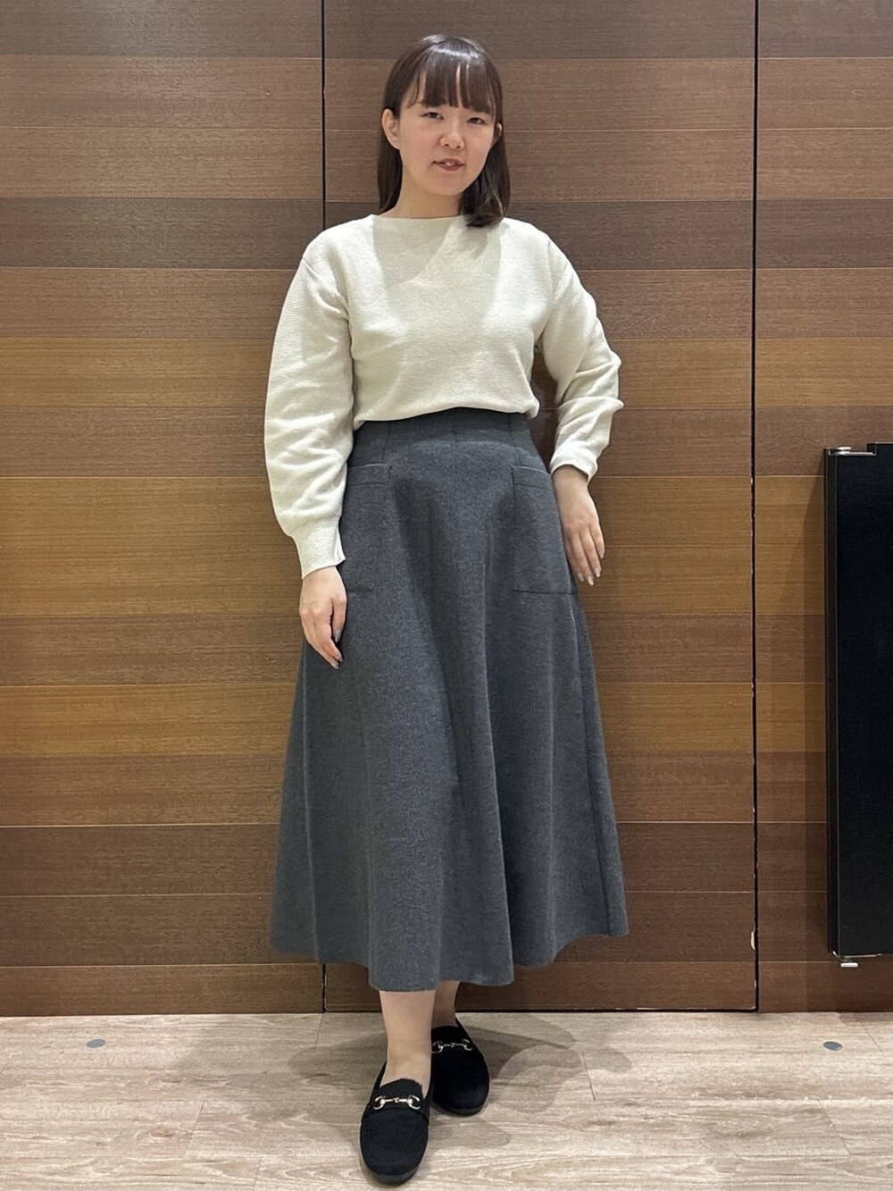 ブルー系のカーディガン/ボレロ、ホワイト系のニット/セーター、グレー系のスカートを着用したレディースの冬コーディネートの9枚目の写真
