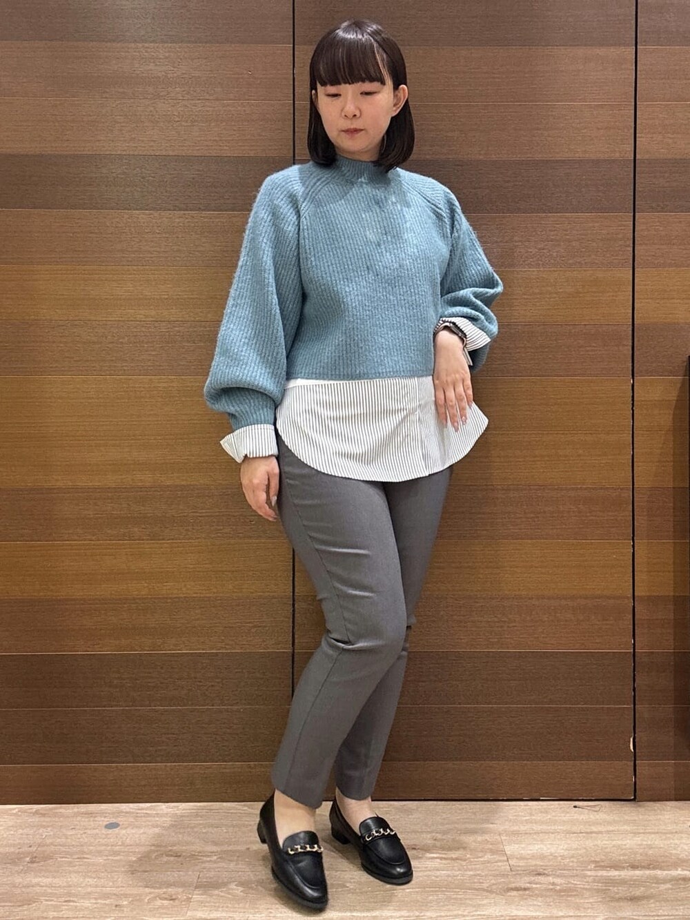 ブルー系のニット/セーター、ホワイト系のTシャツ/カットソー、グレー系のその他パンツを着用したレディースの冬コーディネートの4枚目の写真