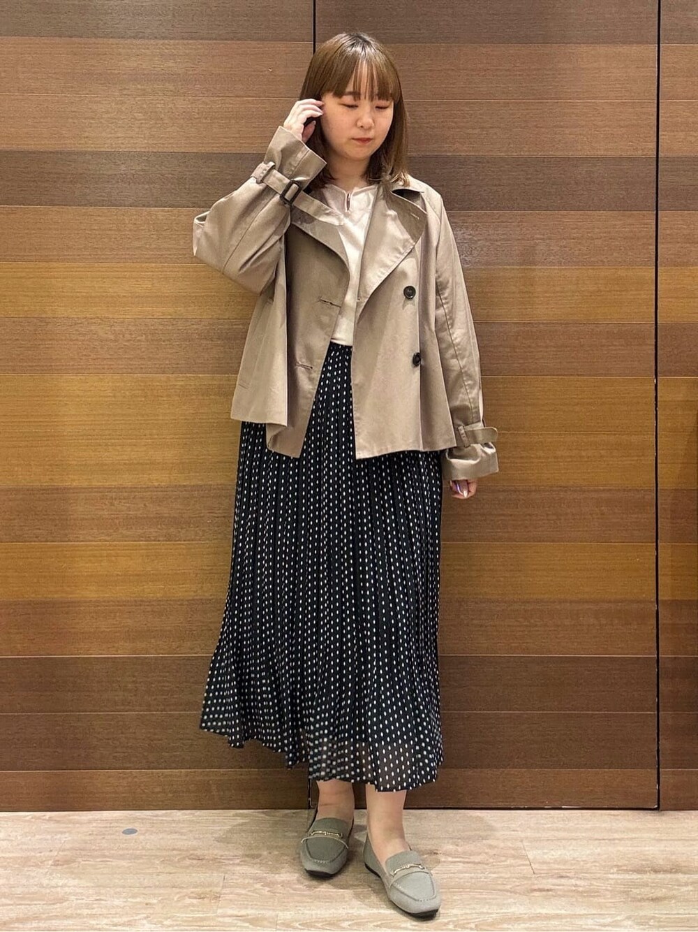 ベージュ系のトレンチコート、ベージュ系のニット/セーター、ベージュ系のその他シューズを着用したレディースの春コーディネートの2枚目の写真