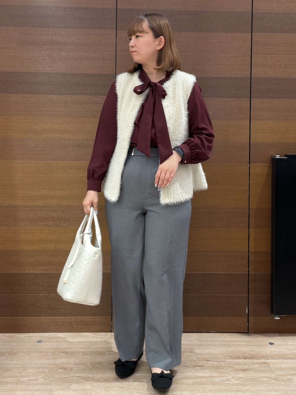 ベージュ系のベスト、レッド系のシャツ/ブラウス、グレー系のその他パンツを着用したレディースの秋コーディネートの4枚目の写真