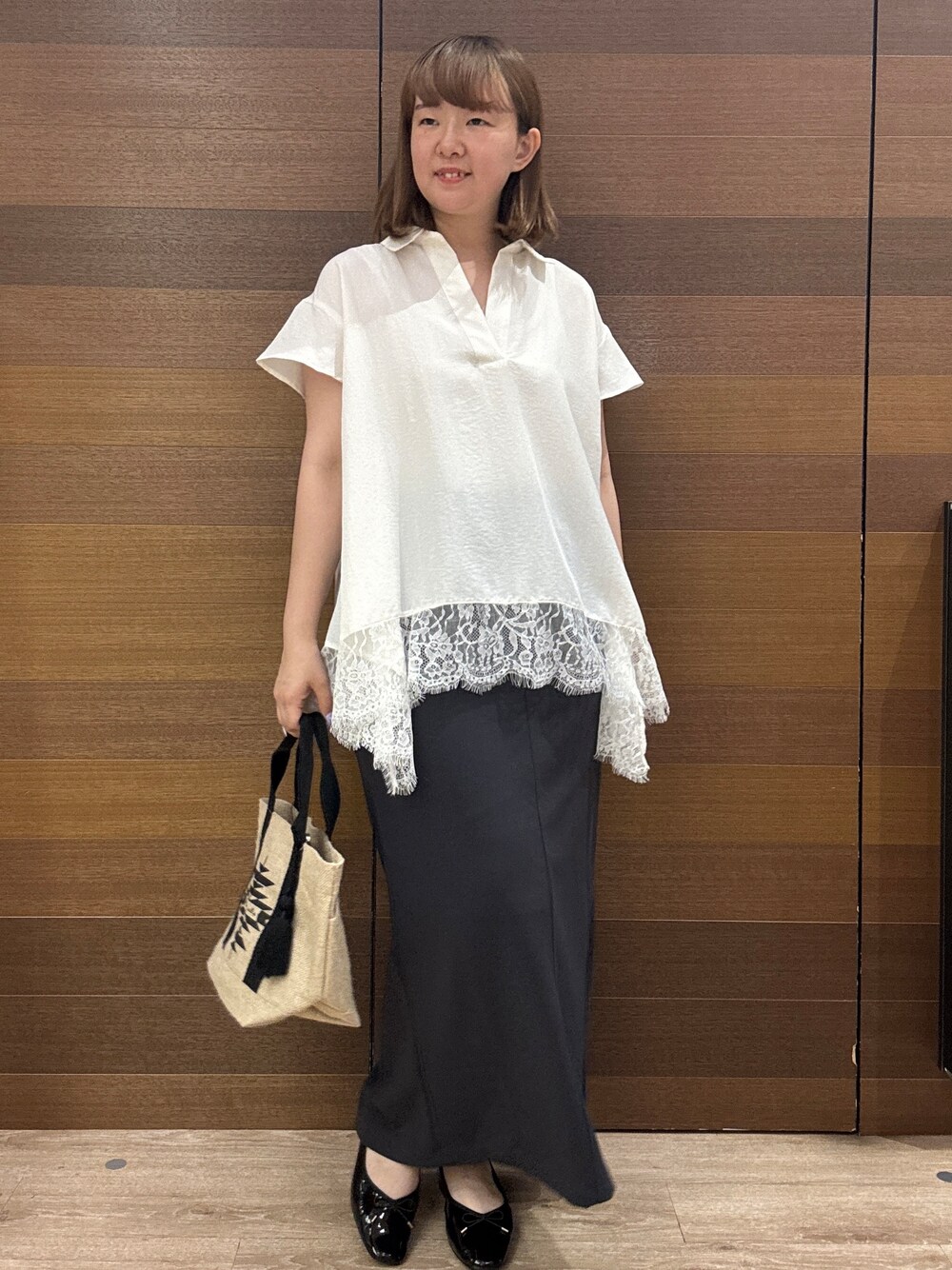 ホワイト系のシャツ/ブラウス、グレー系のスカート、ブラック系のトートバッグを着用したレディースの夏コーディネートの2枚目の写真