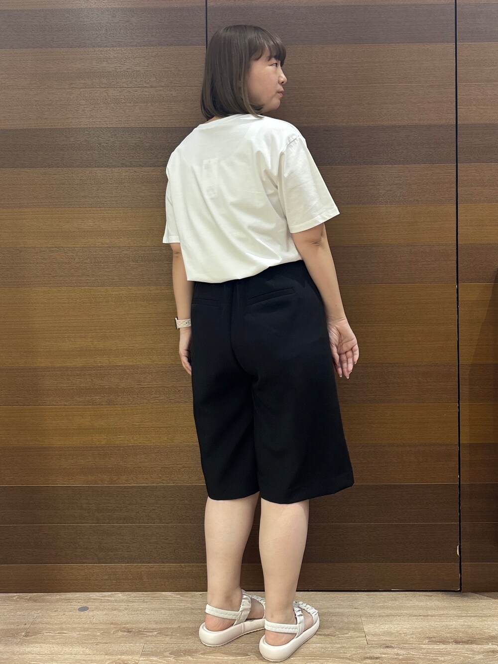 ホワイト系のトートバッグ、ホワイト系のサンダル、ブラック系のその他パンツを着用したレディースの春コーディネートの6枚目の写真