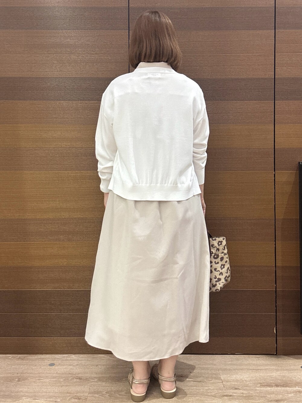 ベージュ系のワンピース、ブラウン系のトートバッグ、ゴールド系のサンダルを着用したレディースの夏コーディネートの6枚目の写真