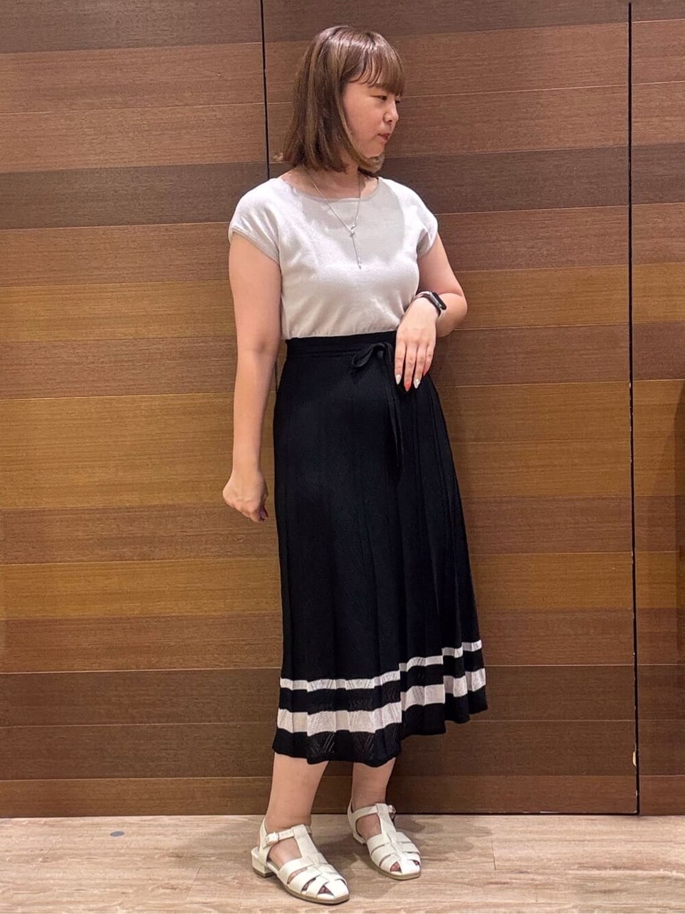 ブラック系のワンピース、シルバー系のショルダーバッグ、ホワイト系のサンダルを着用したレディースの夏コーディネートの3枚目の写真