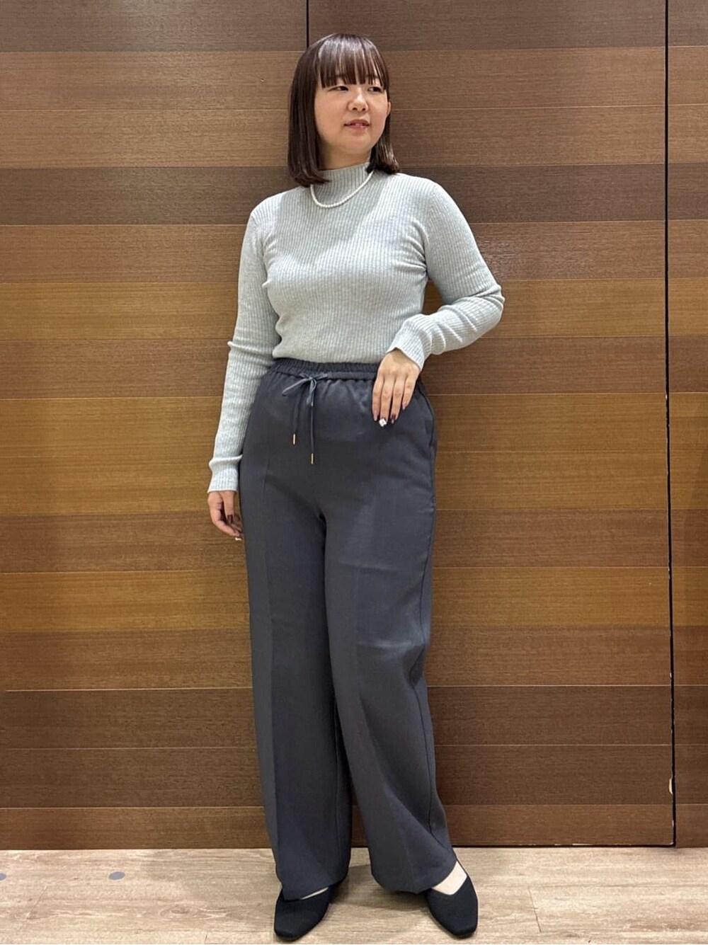 グレー系のニット/セーター、グレー系のその他パンツ、ブラック系のボストンバッグを着用したレディースの冬コーディネートの3枚目の写真