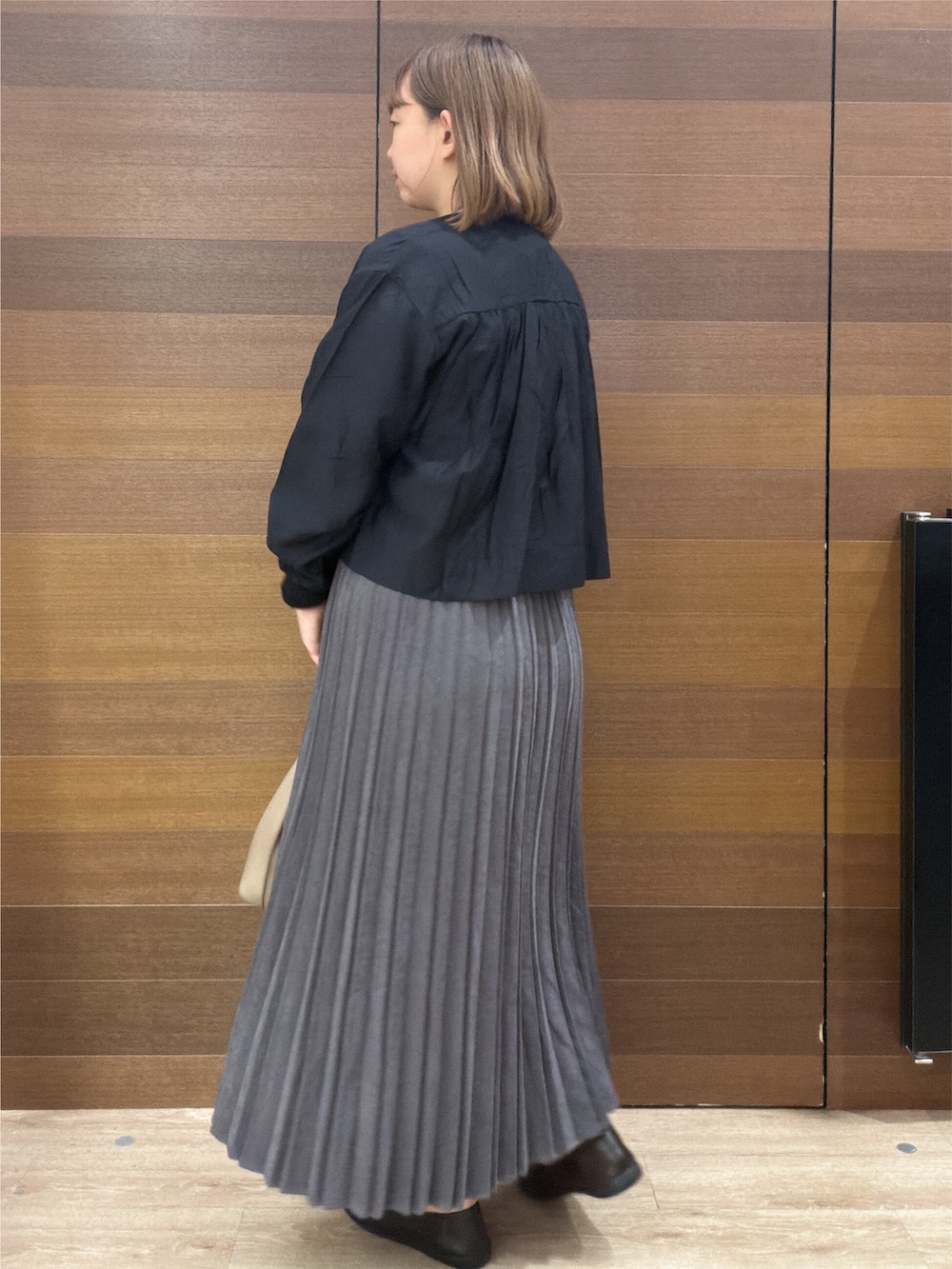 ブラック系のカーディガン/ボレロ、レッド系のニット/セーター、グレー系のスカートを着用したレディースの秋コーディネートの5枚目の写真