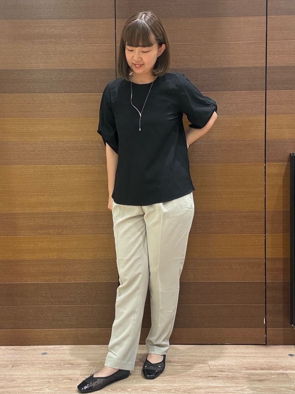 ブラック系のシャツ/ブラウス、ベージュ系のその他パンツ、シルバー系のショルダーバッグを着用したレディースの夏コーディネートの2枚目の写真