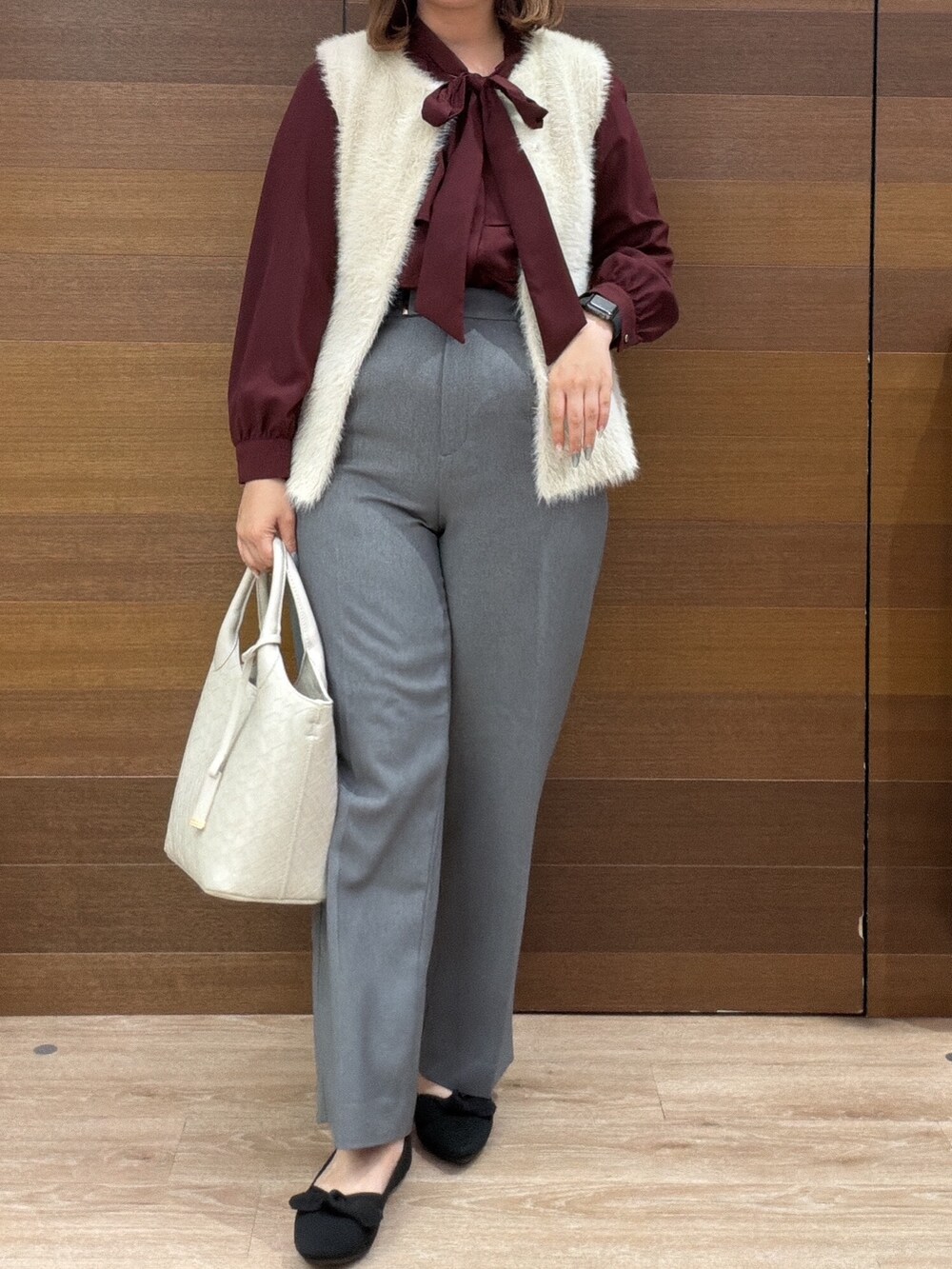 ベージュ系のベスト、レッド系のシャツ/ブラウス、グレー系のその他パンツを着用したレディースの秋コーディネートの7枚目の写真