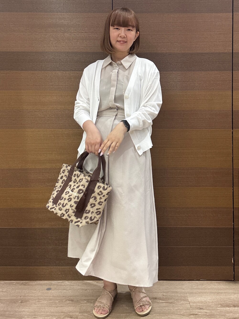 ベージュ系のワンピース、ブラウン系のトートバッグ、ゴールド系のサンダルを着用したレディースの夏コーディネートの2枚目の写真