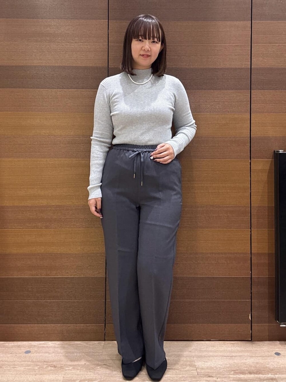 グレー系のニット/セーター、グレー系のその他パンツ、ブラック系のボストンバッグを着用したレディースの冬コーディネートの2枚目の写真