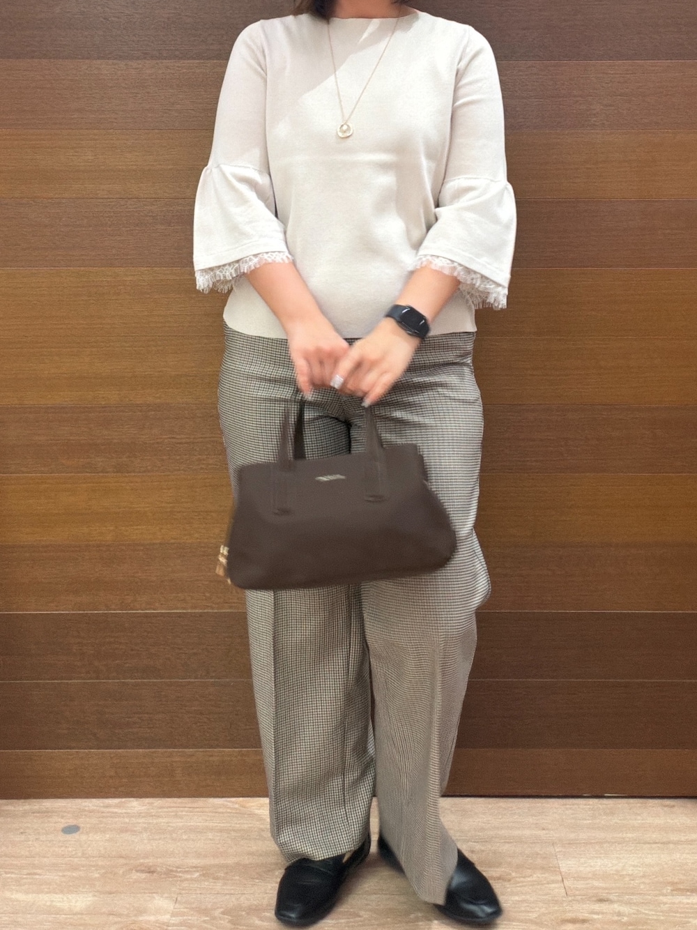 ベージュ系のニット/セーター、ブラウン系のその他パンツ、ブラウン系のボストンバッグを着用したレディースの秋コーディネートの9枚目の写真