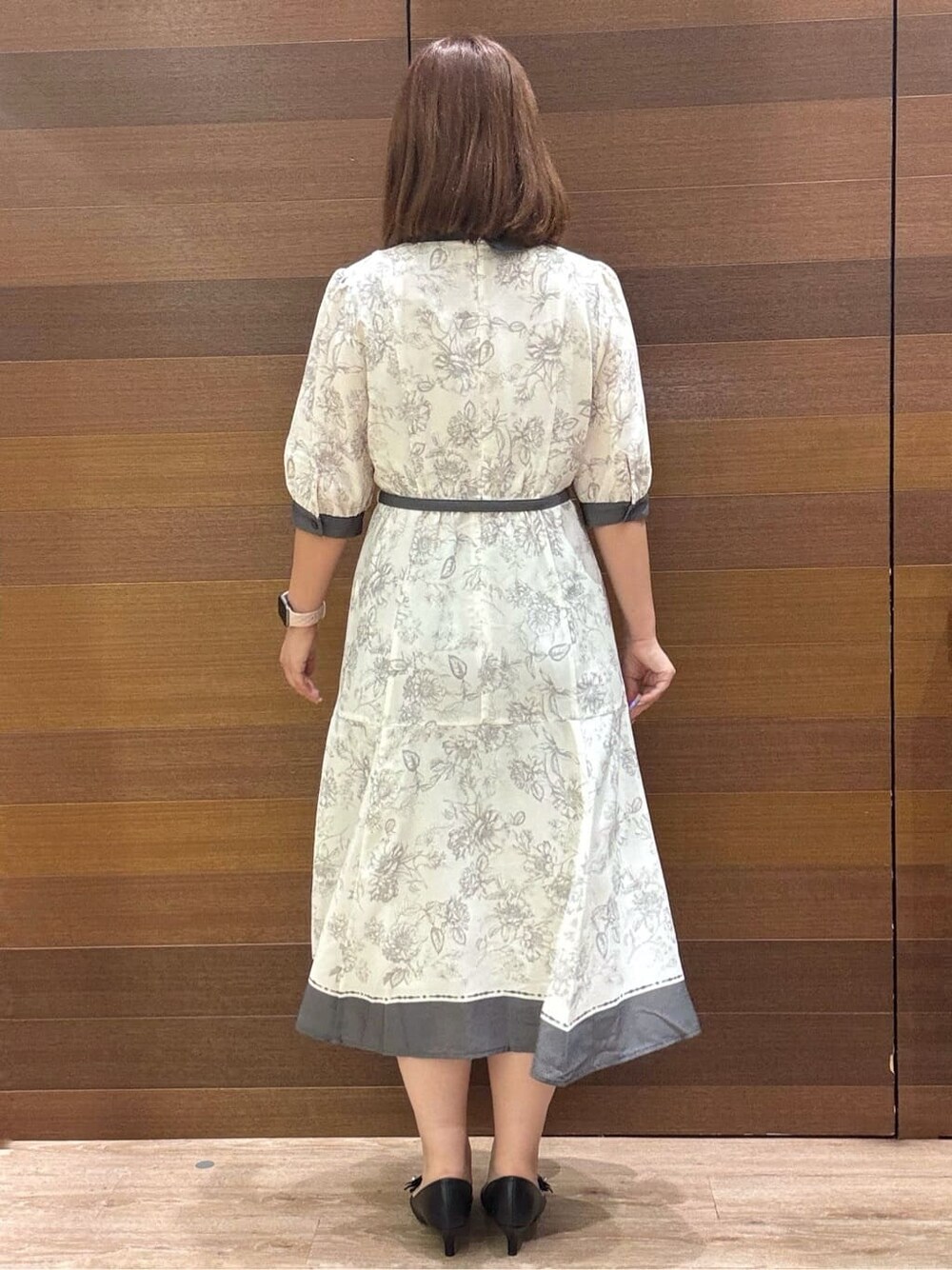 グレー系のワンピース、ベージュ系のショルダーバッグ、ブラック系のパンプスを着用したレディースの夏コーディネートの5枚目の写真