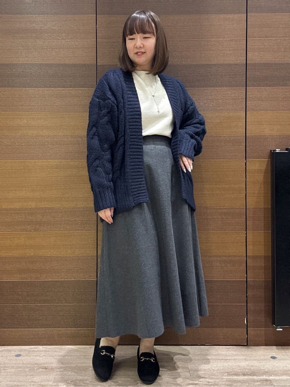 ブルー系のカーディガン/ボレロ、ホワイト系のニット/セーター、グレー系のスカートを着用したレディースの冬コーディネートの4枚目の写真