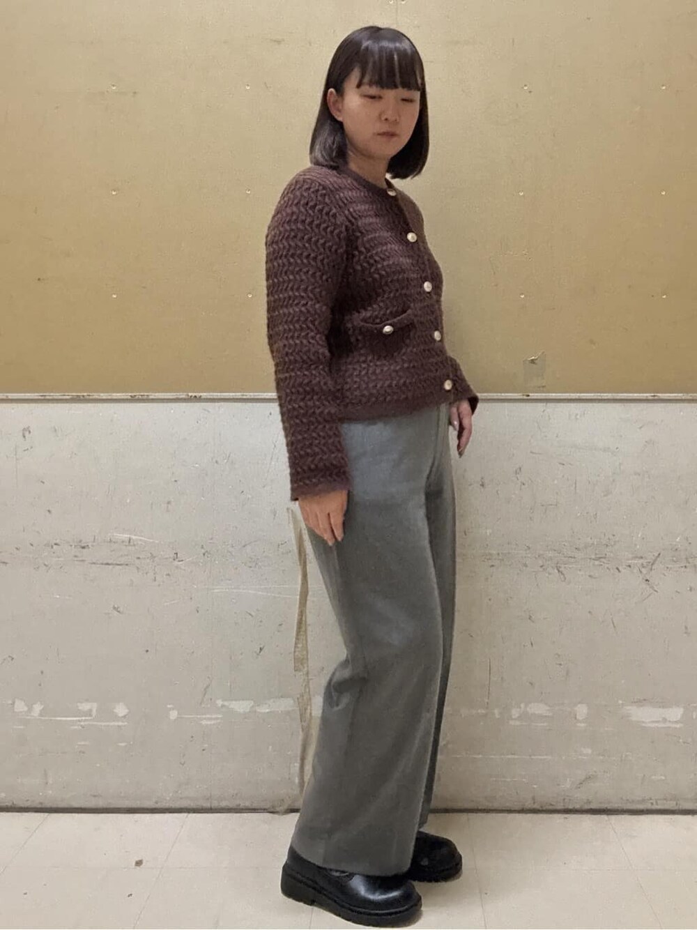 ブラウン系のカーディガン/ボレロ、グレー系のその他パンツ、ブラック系のトートバッグを着用したレディースの冬コーディネートの6枚目の写真