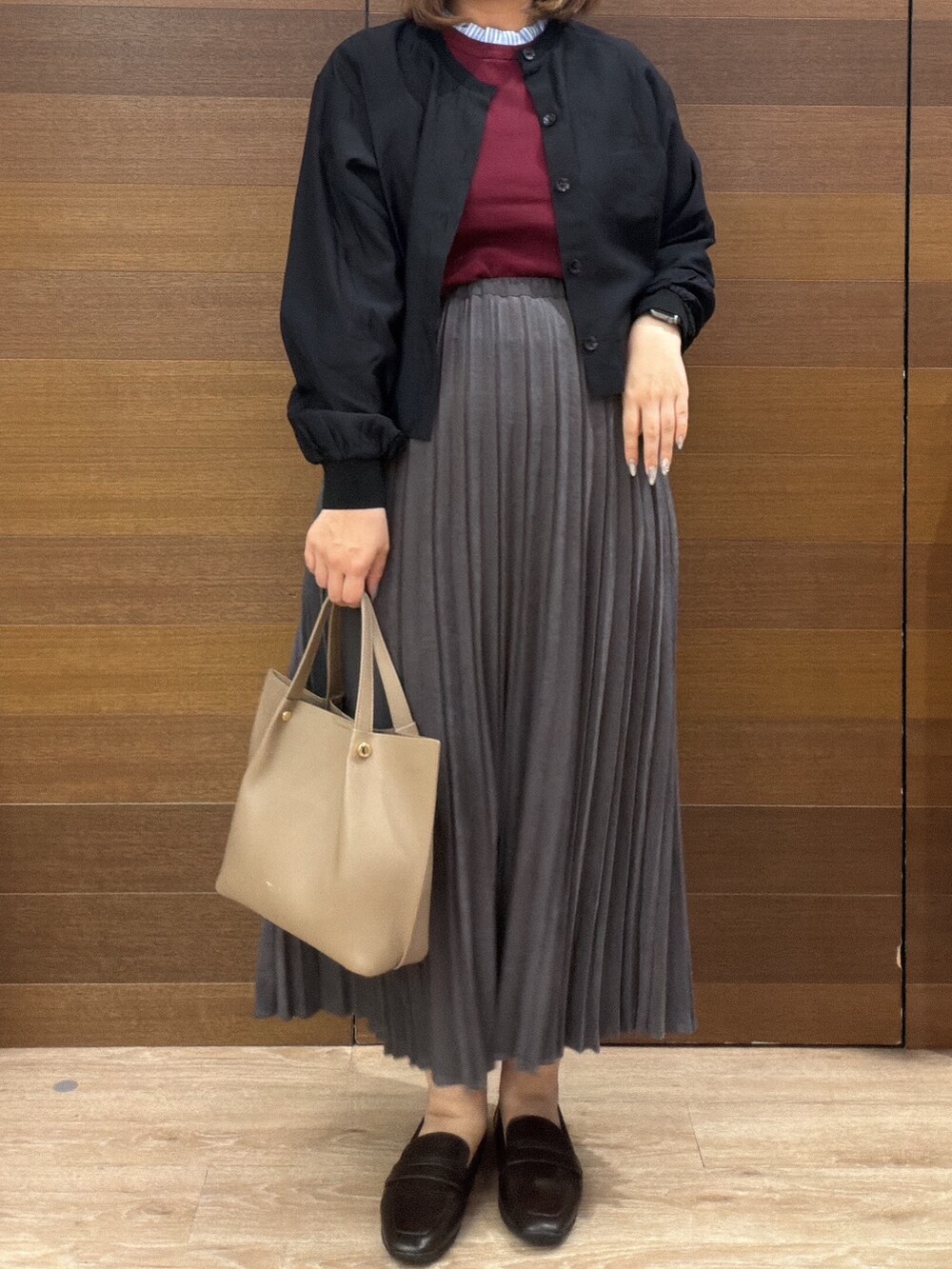 ブラック系のカーディガン/ボレロ、レッド系のニット/セーター、グレー系のスカートを着用したレディースの秋コーディネートの6枚目の写真