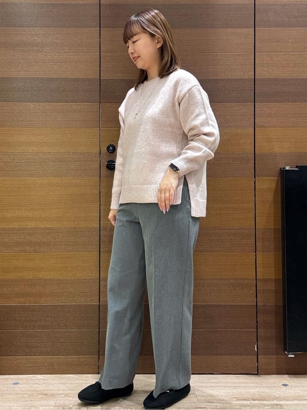 ピンク系のニット/セーター、グレー系のその他パンツ、ブラック系のパンプスを着用したレディースの冬コーディネートの3枚目の写真