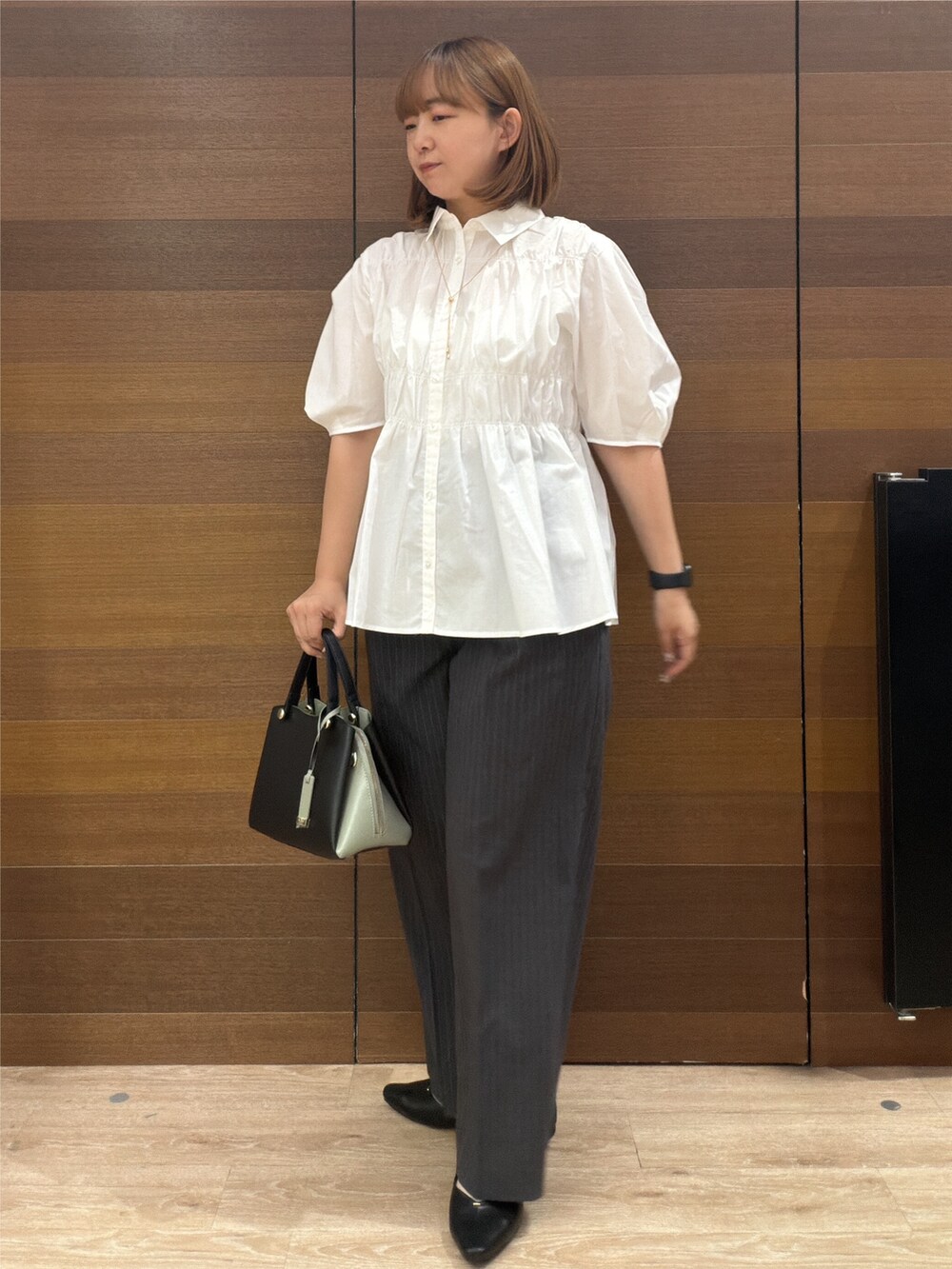 ホワイト系のシャツ/ブラウス、グレー系のその他パンツ、ブラック系のボストンバッグを着用したレディースの夏コーディネートの6枚目の写真