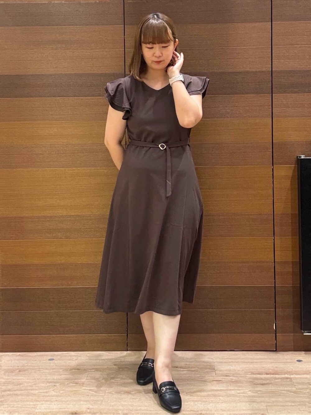 ブラウン系のワンピース、ベージュ系のトートバッグ、ブラック系のパンプスを着用したレディースの夏コーディネートの2枚目の写真