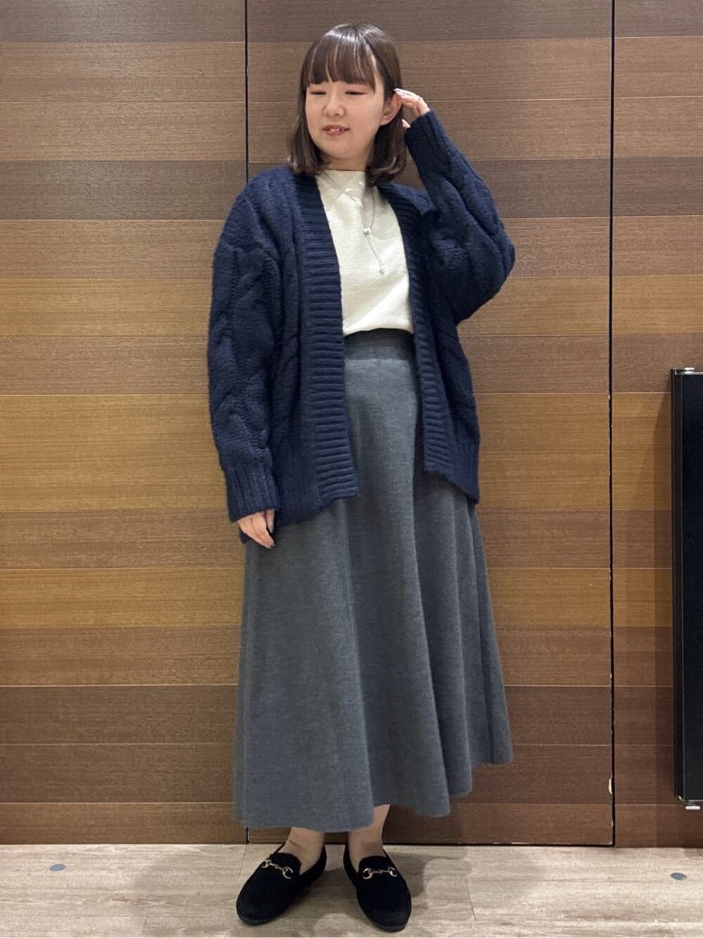 ブルー系のカーディガン/ボレロ、ホワイト系のニット/セーター、グレー系のスカートを着用したレディースの冬コーディネートの5枚目の写真