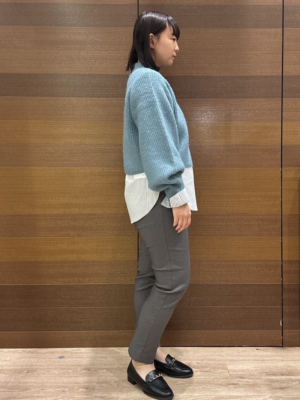 ブルー系のニット/セーター、ホワイト系のTシャツ/カットソー、グレー系のその他パンツを着用したレディースの冬コーディネートの7枚目の写真