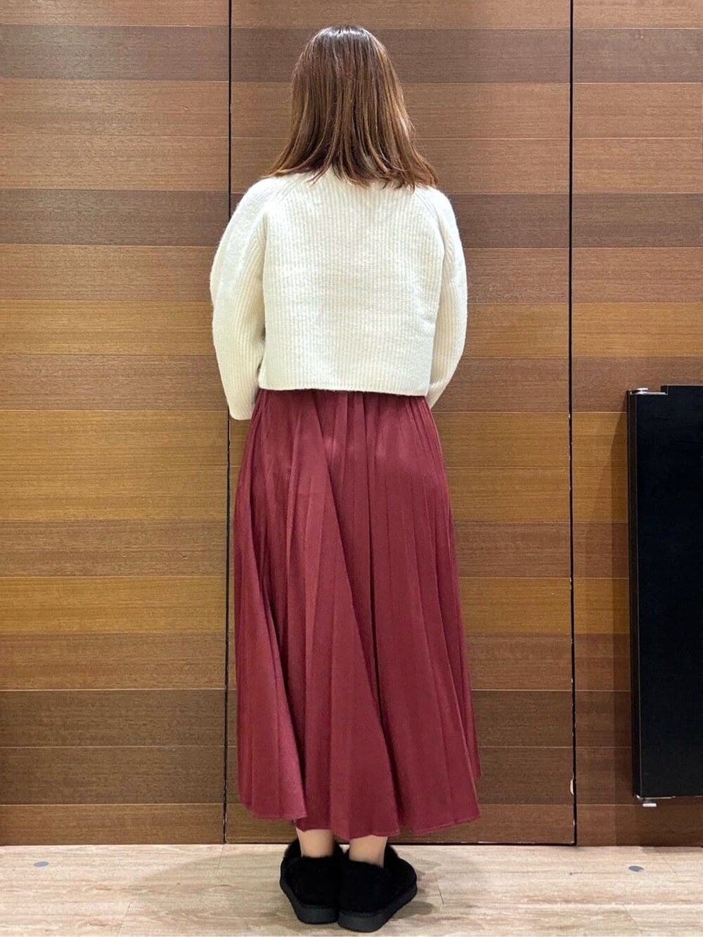 ベージュ系のピーコート、ホワイト系のニット/セーター、レッド系のスカートを着用したレディースの冬コーディネートの10枚目の写真